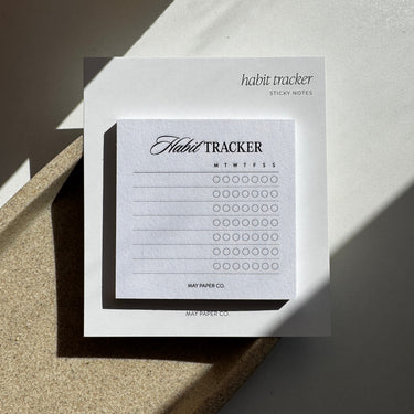 Habit tracker sticky notes on a textured surface with shadows